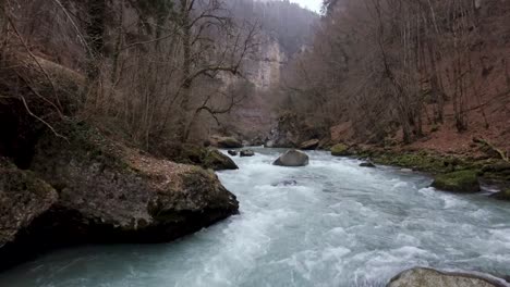 Eine-Drohne-Fliegt-An-Einem-Nebligen,-Düsteren-Wintertag-über-Eine-Flussschlucht