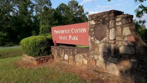 Close-up-slanted-view-of-Providence-Canyon-State-Park-sign-in-Lumpkin-Georgia-on-bright-sunny-day