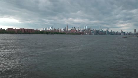 Mann-Blickt-Von-Einem-Der-Besten-Aussichtspunkte-Der-Stadt-In-Long-Island-City-Queens-Auf-Die-Skyline-Von-New-York,-Während-Die-Drohne-Vorbeifliegt,-Um-Das-Stadtbild-Zu-Bewundern