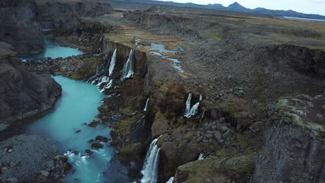 Vista-Aérea-Del-Crepúsculo-Sobre-Cascadas-Celestiales-Y-Cañón-Volcánico-Con-Agua-Azul-Del-Río-Glacial,-Islandia