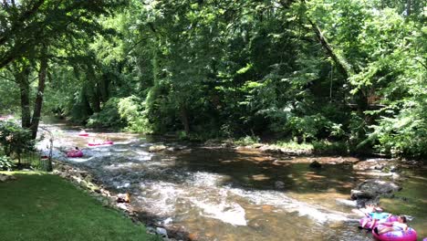 Familias-Navegando-Por-El-Río-Chattahoochee-En-Helen,-Georgia,-Mientras-Flotan-A-Través-De-Rápidos-Y-Sobre-Pequeñas-Cascadas