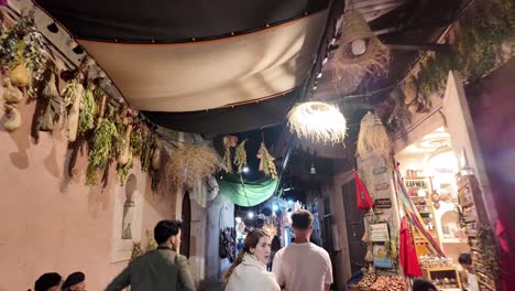 Medina-old-town-streets-at-night-with-tourists-and-open-shops,-Marrakesh-Morocco