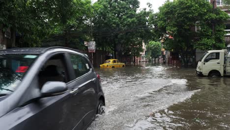 Cars-moving-through-the-water-logged-streets-of-Kolkata,-West-Bengal,-India