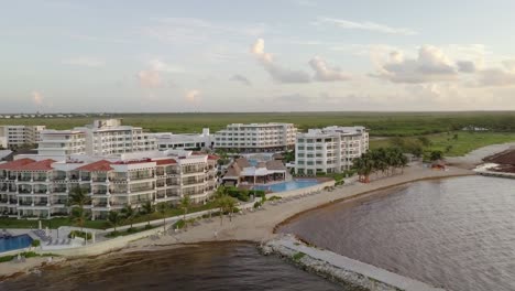 AERIAL---Hotels,-swimming-pools-and-a-small-bay-in-Cancun,-Mexico,-circle-shot