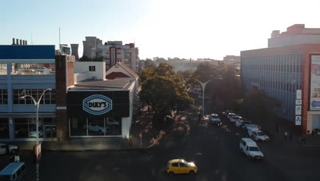 A-push-down-drone-shot-of-a-busy-city-area-Bulawayo,-Zimbabwe-at-sunset