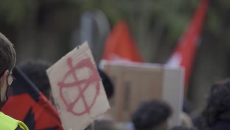 Man-who-participate-in-demonstration-is-holding-a-poster-with-symbol-of-Anarchy