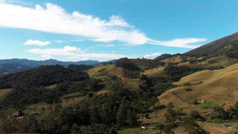 Aerial-view-of-the-Pico-dos-Marins-mountain-range-in-Minas-Gerais,-Brazil,-showcasing-lush-green-hills-and-a-clear-blue-sky