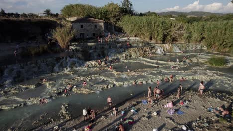 -Aufnahme:-Rückstoß--Beschreibung:-Drohnenvideo-über-Den-Thermen-Von-Saturnia,-Italien,-Man-Sieht-Menschen-Beim-Baden