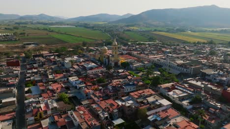 Dolly-in-tilt-up-flight-over-residential-area-reveals-Santuario-Diosesano-church-in-Tamazula-city-center