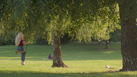 Una-Joven-Se-Balancea-En-Un-Columpio-En-El-Parque-De-La-Ciudad.