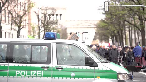 German-police-car-with-sirens-at-a-demonstration-in-major-city-Munich,-Germany