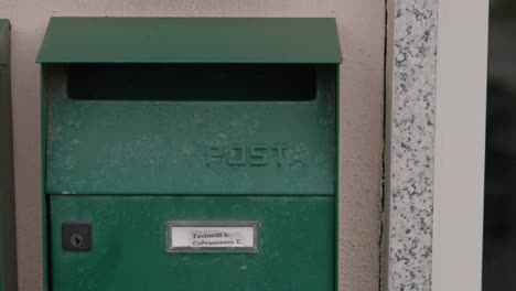 Close-up-of-green-old-style-mailbox-hanging-on-a-wall