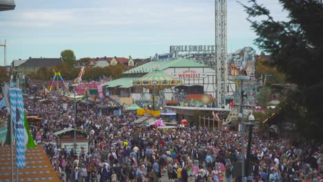 A-lot-of-people-in-traditional-Tracht---Lederhosen---Dirndl-clothes-walking-across-the-famous-Bavarian-Oktoberfest---Wiesn-in-Munich