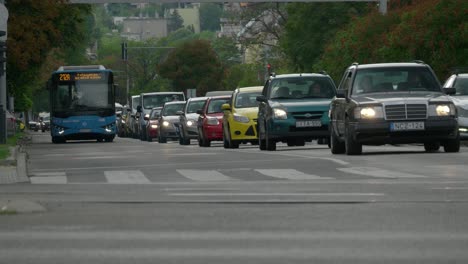 Tele-Footage-Of-A-Scooter-And-Blue-Bus-Coming-In-Heavy-Traffic,-Streets-Of-Budapest,-2022-September