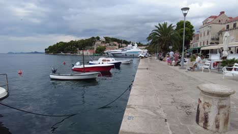 Leisurely-stroll-along-the-coastal-pathway-near-the-water,-where-small-boats-gently-float-alongside-docked,-capturing-the-serene-charm-of-Cavtat,-Croatia