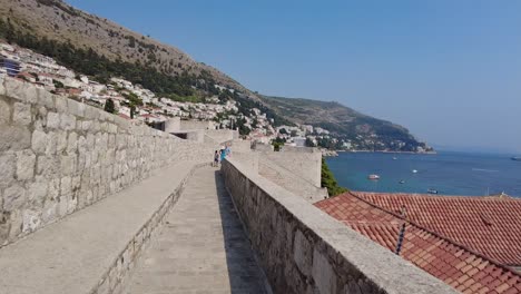 Ein-Spaziergang-Entlang-Der-Stadtmauern-Von-Dubrovnik-An-Einem-Sonnigen-Tag-Verkörpert-Die-Essenz-Historischer-Erkundung-Und-Lebendiger-Reiseerlebnisse