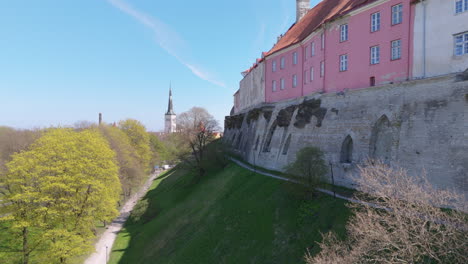 Rosafarbene-Gebäude-Auf-Den-Mittelalterlichen-Mauern-Der-Altstadt-Von-Tallinn,-Vanalinn,-Drone-Riser