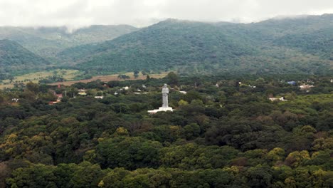 A-panoramic-aerial-view-of-the-city-of-La-Caldera-in-Salta,-Argentina,-showcasing-its-famous-statue-of-the-"Cristo-Penitente