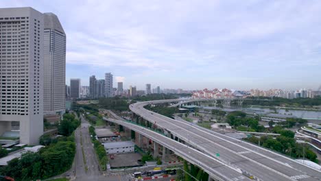 Sunset-flight-over-the-Singapore-city-highway-road-marina-bay-downtown-aerial-panorama-4k-drone-video