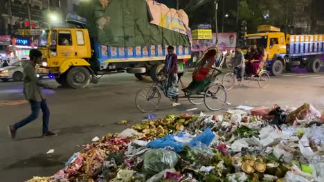 A-Nighttime-View-of-Garbage-Strewn-Across-the-Street-in-Dhaka,-Bangladesh---Handheld-Shot