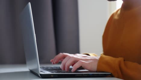 close-up-shot-of-a-man's-hands-and-chest-working-on-his-laptop-computer