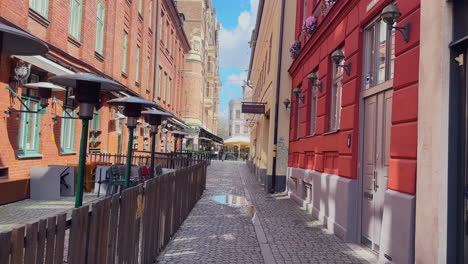 Moving-forward-towards-Lilla-Torg-in-Malmö-through-a-small-picturesque-alley-with-a-cobblestone-path