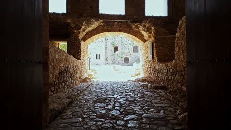 Frankish-Chlemoutsi-Castle-entrance-grand-archway-with-stone-walls-and-cobblestone-path