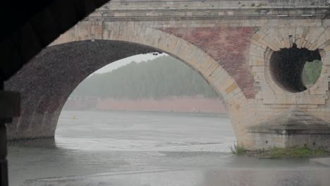 Rainy-day-under-Pont-Neuf-bridge,-river-flowing-in-Toulouse,-France