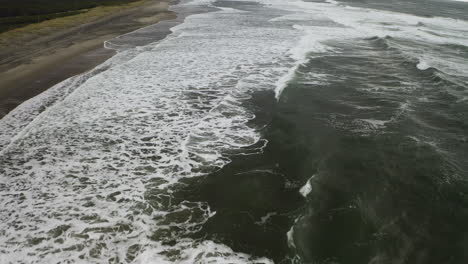 Seashore-Aerial-View-Along-Beach-Of-Ocean-Waves-and-Water-Foam,-Neskowin-Oregon-Coast-USA