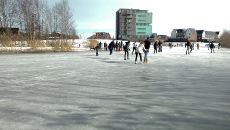 Die-Menschen-Genießen-Den-Winterfrost-Auf-Dem-Zugefrorenen-Teich-Beim-Schlittschuhlaufen-Und-Spazierengehen-Auf-Dem-Eis