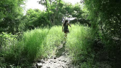 HD-Frau-Wandert-An-Einem-Sonnigen-Tag-Mit-Stock-Durch-Grasland-Und-Wald-In-Thailand