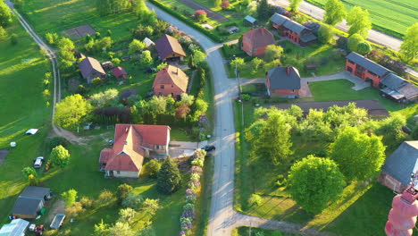 Dorf-Mit-Häusern-Und-Wasserturm-In-Drohnenansicht-Mit-Goldenem-Sonnenlicht