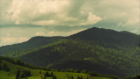 Timelapse-photo-showing-tall-mountains-covered-in-dense-green-coniferous-forests,-shadows-of-clouds-passing-by