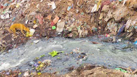 Flowing-Waste-Water-Through-Pile-Of-Garbages-Near-Buriganga-River-In-Dhaka,-Bangladesh,-Asia