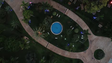 Aerial-view-of-a-wedding-venue-with-swimming-pool-in-the-middle-of-the-frame-spinning-and-flying-higher-to-reveal-the-beautiful-luxurious-wedding-venue