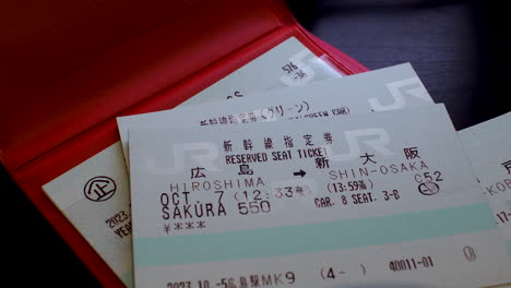 Stapeln-Von-Japan-Rail-Pass-Tickets-Für-Hochgeschwindigkeitszüge-Auf-Einer-Roten-Reisebrieftasche-Auf-Dem-Tisch