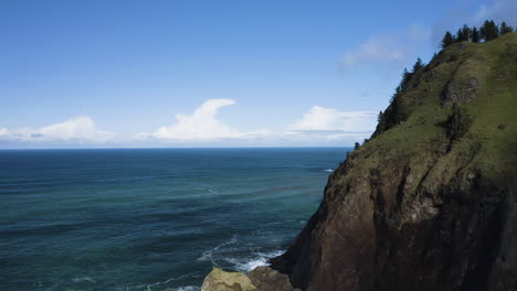 Aerial-View-Of-Rocky-Cliffs-Along-Oregon-Coast-With-Turquoise-Ocean-and-Skyline,-God's-Thumb-USA