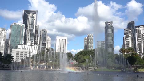 Espectáculo-De-Fuentes-En-Un-Parque-Público-En-Cámara-Lenta-Con-Un-Edificio-Emblemático-En-El-Fondo