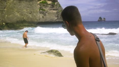 Tan-stylish-man-walks-along-beautiful-tropical-beach-on-sunny-day