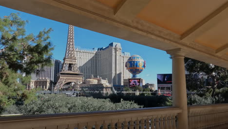 Las-Vegas-Strip-Skyline-on-Sunny-Day,-Paris-Casino-Hotel,-Eiffel-Tower-and-Balloon,-Revealing-Shot