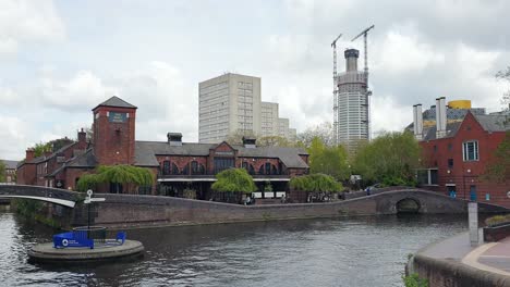 Scenic-street-view-overlooking-canal-and-Old-Turn-Junction-with-signpost-directions-to-Wolverhampton-and-Fazeley-in-Birmingham,-the-Midlands-of-England-UK