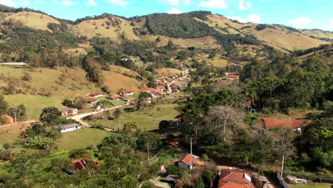 Un-Dron-Que-Se-Eleva-Sobre-Un-árbol-Captura-Imágenes-Impresionantes-De-Un-Pintoresco-Pueblo-Ubicado-En-Medio-De-Verdes-Colinas