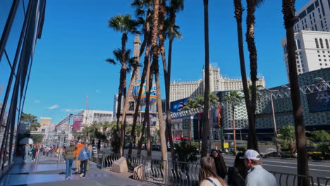 Las-Vegas-USA,-Pedestrians-and-Strip-Traffic-on-Sunny-Day,-Mirror-Reflection-on-Cosmopolitan-Casino-Hotel,-Panorama