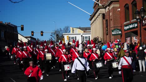 Eine-In-Rot-Und-Weiß-Gekleidete-Blaskapelle-Mit-Kleiner-Trommel-Spielt-Schlagzeug-Und-Marschiert-Während-Der-Thanksgiving-Parade-2019-In-Plymouth,-Massachusetts,-Die-Hauptstraße-Entlang