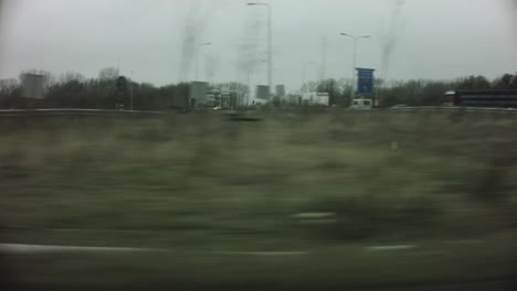 Beverwijk-Netherlands-Jan-:-car-ridding-view-of-forest-trees-and-town-traffic-light-signs-passing