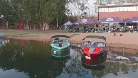 Tracking-around-two-water-ski-boats-parked-at-the-river-bank