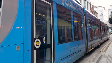 West-Midlands-Metro-light-rail-tram-systems-traveling-in-the-opposite-direction-traveling-past-Bullring-and-Grand-in-the-county-of-West-Midlands,-Birmingham,-England-UK