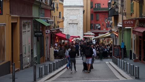 Bustling-street-in-Old-Town-Nice-with-colorful-buildings,-people,-and-outdoor-cafes