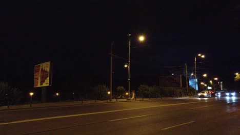 Walking-on-Bucharest-streets-at-night-near-the-road-with-cars-with-a-storm-coming