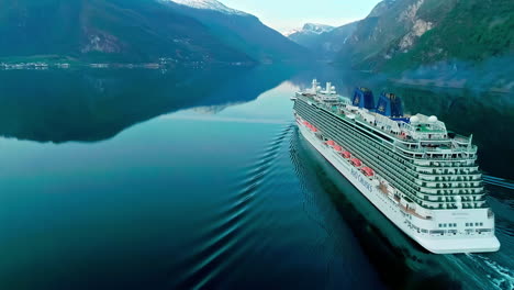 Massive-cruise-vessel-sailing-through-Norway-fjords-in-Aurland,-aerial-view